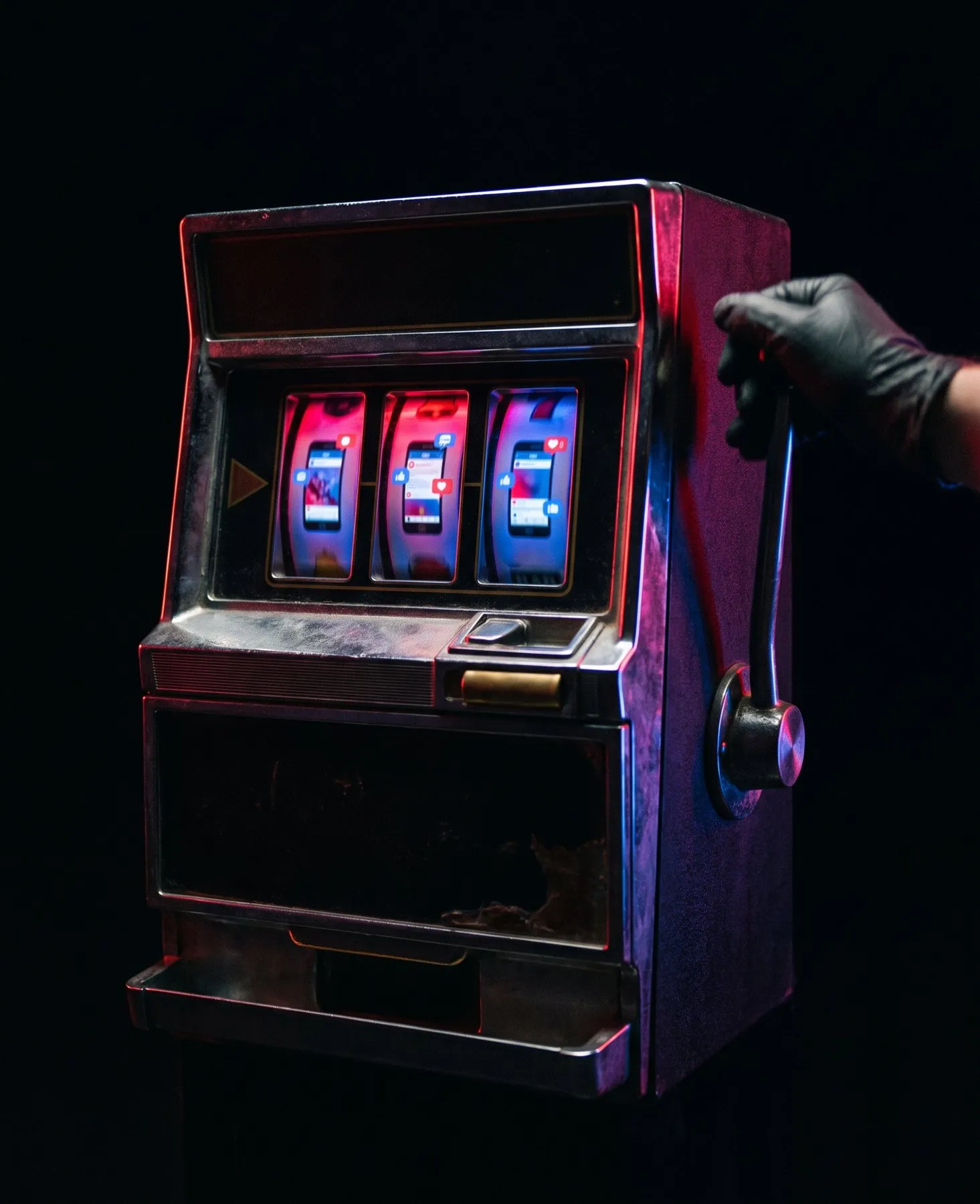 Una vecchia slot machine: al posto dei simboli, i rulli mostrano schermate di un social con cuori, like e commenti. Una mano guantata stringe la leva.